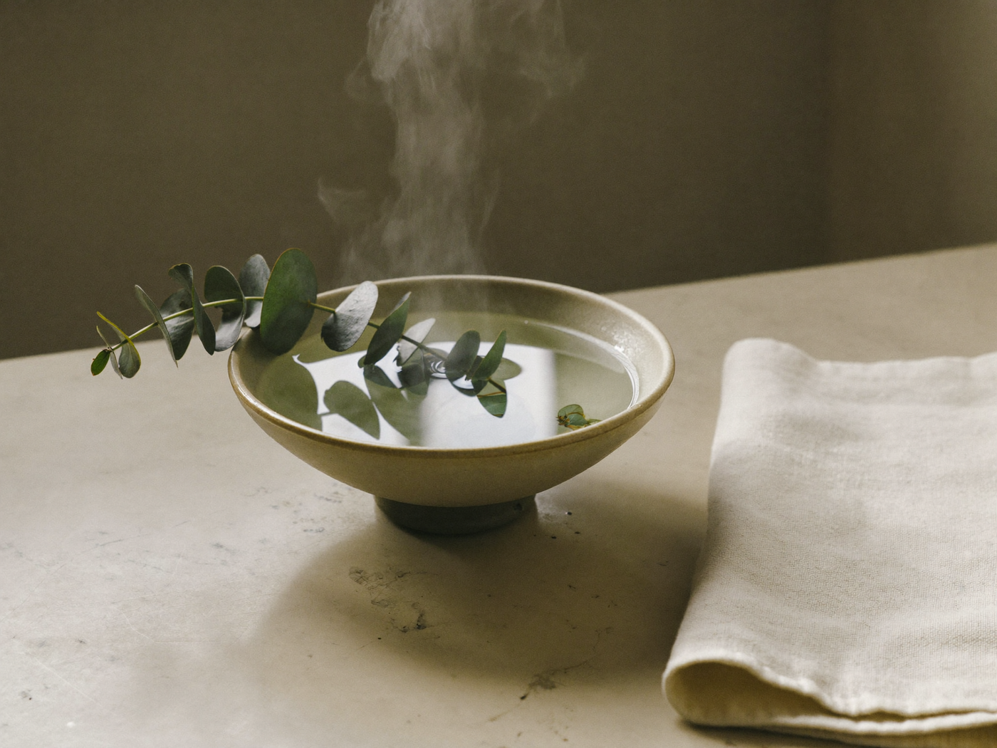 eucalyptus sprigs over a bowl of steaming water